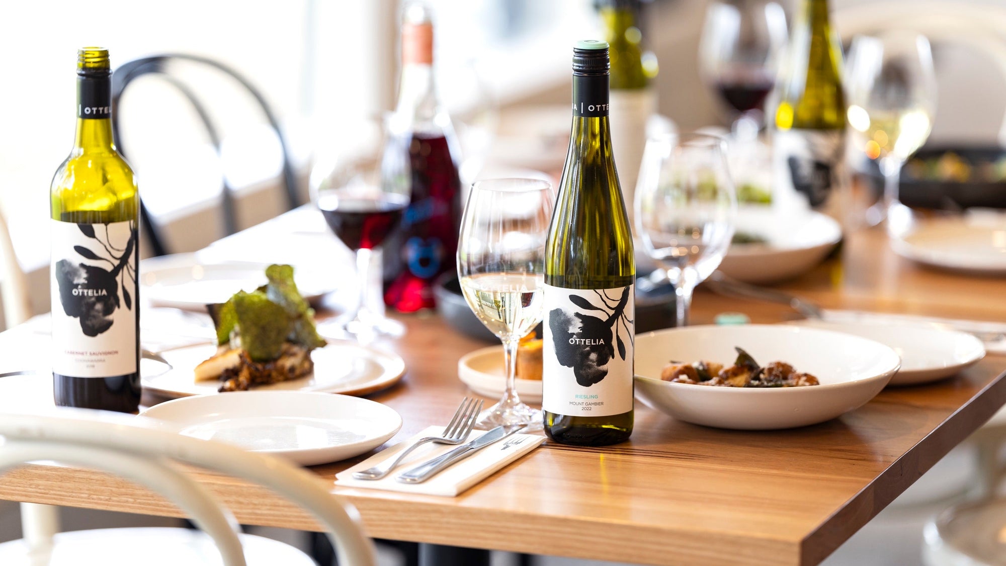 A selection of dishes to share at Ottelia, there is a bottle of Mount Gambier Riesling and a bottle of Coonawarra Cabernet on the table.